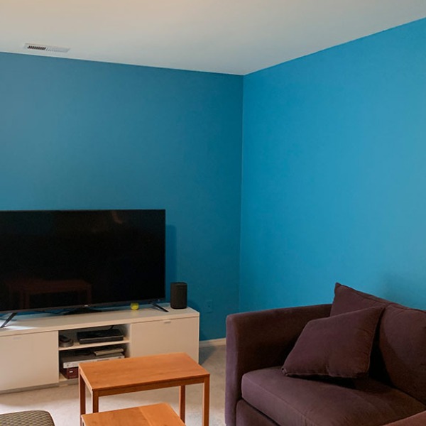 A living room with blue walls and brown furniture.